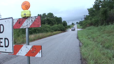 A-Driver-Ignores-A-Road-Closed-Sign-And-Drives-Through-A-Flooded-Area