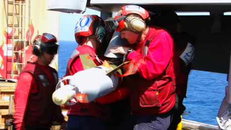 Navy-Men-Load-Warheads-Onto-A-Fighter-Jet