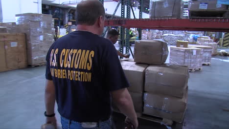Homeland-Security-Agents-Search-Through-A-Warehouse-In-A-Shipping-Facility