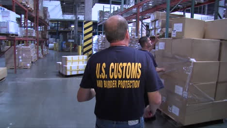 Homeland-Security-Agents-Search-Through-A-Warehouse-In-A-Shipping-Facility-1