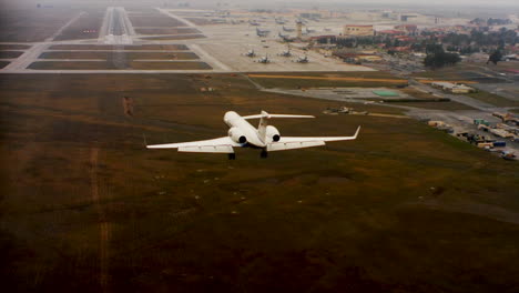 Aerial-Of-A-Private-Jet-Landing-At-An-Airport-From-Behind