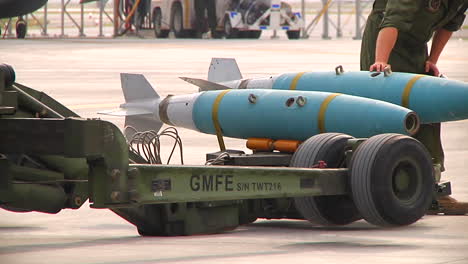 Bombs-Are-Loaded-Onto-A-Jet-Aircraft-By-Military-Personnel