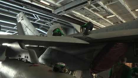 Männer-Und-Frauen-Arbeiten-An-Flugzeugen-In-Einem-Hangar-Auf-Einem-Flugzeugträger