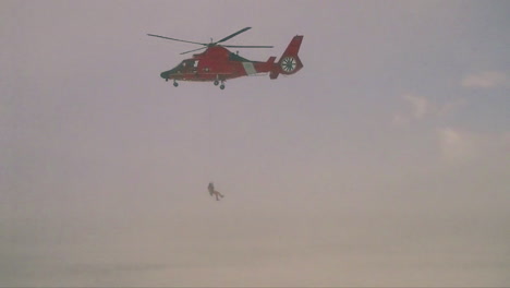An-Airman-Descends-From-A-Coast-Guard-Search-And-Rescue-Helicopter-In-A-Blizzard