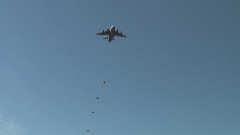 Vista-Del-ángulo-Del-Suelo-De-Los-Paracaidistas-Que-Se-Lanzan-En-Paracaídas-A-La-Tierra-Desde-Un-C17-4