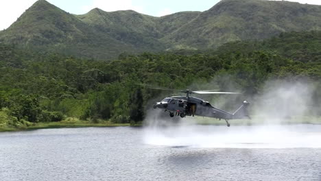 Los-Paracaidistas-Saltan-De-Un-Helicóptero-Que-Vuela-A-Baja-Altura-A-Un-Lago