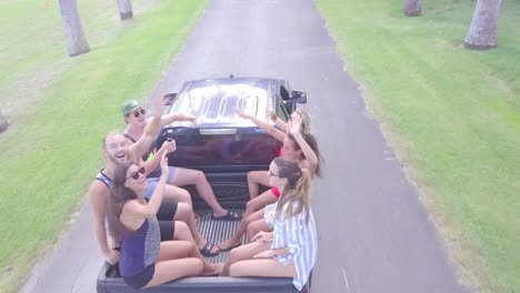 A-Drone-Aerial-Over-Young-People-Sitting-In-The-Back-Of-A-Pickup-Truck-Having-A-Good-Time-In-Barbados-Caribbean