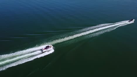 Vista-Aérea-Over-Two-Speedboats-Racing-Fast-Across-Blue-Water