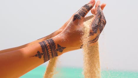 Eine-Schöne-Frau-Mit-Henna-Tattoos-Nimmt-In-Zeitlupe-Sand-In-Der-Hand-Auf-2
