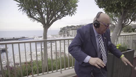 A-Businessman-In-A-Suit-Dances-On-The-Street-With-Headphones-And-A-Group-Of-Young-People-In-Monaco