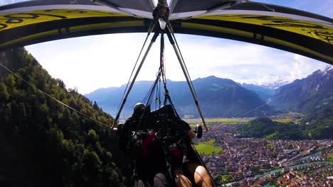 Schöne-Gopro-Pov-Luftaufnahme-Eines-Hängegleiters,-Der-über-Schweizer-Alpen-Und-Dörfer-Fliegt