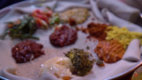 Rack-Fokus-Auf-äthiopisch-afrikanischem-Injera-Essen-Auf-Einem-Silbernen-Tablett