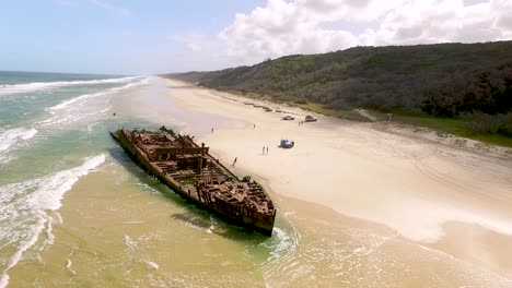 La-Gente-Se-Acerca-A-Un-Antiguo-Naufragio-En-Una-Playa-De-Fraser-Island-Frente-A-La-Costa-De-Queensland,-Australia