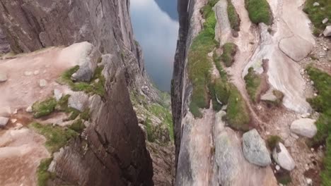 Eine-Luftaufnahme-Zeigt-Ein-Paar,-Das-Auf-Kjeragbolten-Steht,-Einem-Boulder-Auf-Dem-Kjerag-berg-In-Rogaland-Norwegen