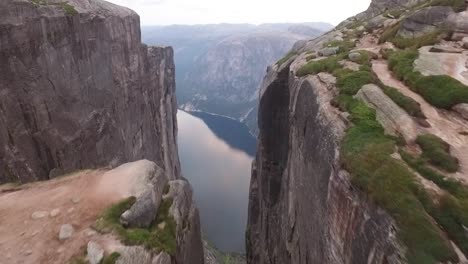 An-aerial-view-shows-a-couple-standing-on-Kjeragbolten-a-boulder-on-the-Kjerag-mountain-in-Rogaland-Norway-1