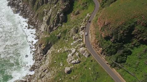 Eine-Vogelperspektive-Zeigt,-Wie-Autos-Entlang-Des-Chapman&#39;s-Peak-In-Südafrika-Am-Meer-Entlang-Fahren