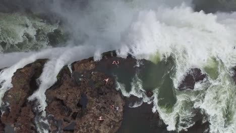 Eine-Vogelperspektive-Zeigt-Touristen,-Die-Auf-Victoria-Falls-Am-Devil&#39;s-Pool-In-Sambia-Schwimmen