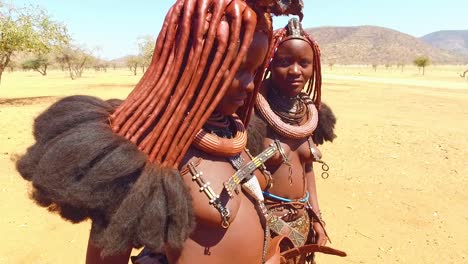 Dos-Jóvenes-Mujeres-Tribales-Himba-Muestran-Sus-Extensiones-De-Cabello-De-Barro-Y-Sus-Inusuales-Peinados-Trenzados-Con-Rastas