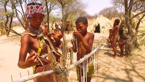 Familia-De-Bosquimanos-Tribales-San-Africanos-En-Sus-Chozas-En-Una-Pequeña-Aldea-Primitiva-En-Namibia-África