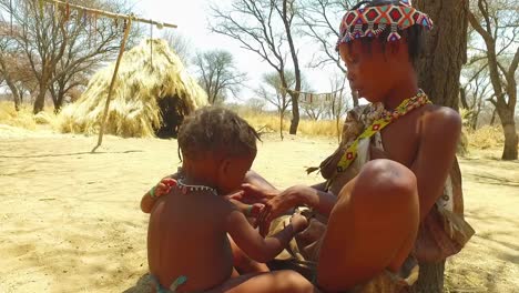 Afrikanische-San-Stammesfrau-Und-Ihr-Baby-In-Einem-Kleinen-Primitiven-Dorf-In-Namibia-Afrika