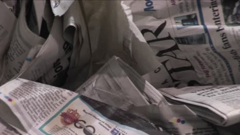 Old-crinkled-newspapers-sit-in-a-recycling-bin-in-a-factory