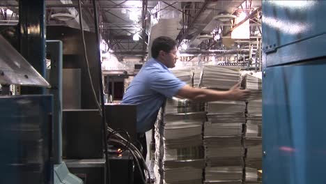 A-machine-stacks-and-binds-newspapers-in-a-factory-then-we-zoom-into-a--stack-of-papers-1