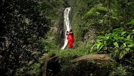 Ein-Hawaiianer-Führt-Ein-Ritual-Vor-Einem-Tropischen-Wasserfall-Durch
