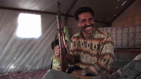 A-man-holds-an-assault-rifle-in-a-tent-in-Iran