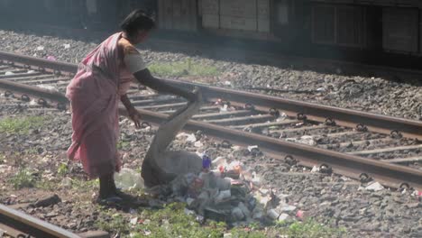 Una-Mujer-Arroja-Una-Bolsa-De-Basura-En-Las-Vías-Del-Tren