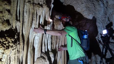 A-man-in-a-cave-plays-stalactites-like-a-musical-instrument