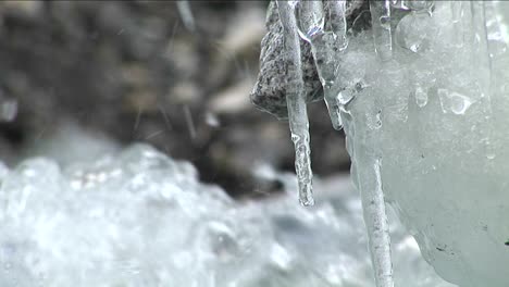 Water-dripping-off-icicles-water-rushing-by