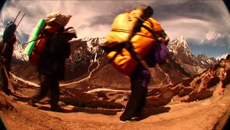 Fish-eye-shot-of-porters-passing-by-on-trail-in-Himalayas