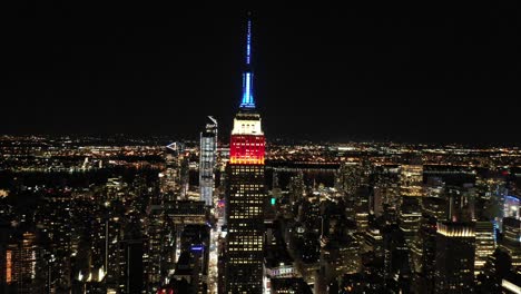 Buena-Antena-De-La-Torre-Del-Empire-State-Building-Iluminado-En-Rojo,-Blanco-Y-Azul-En-La-Ciudad-De-Nueva-York-Nueva-York