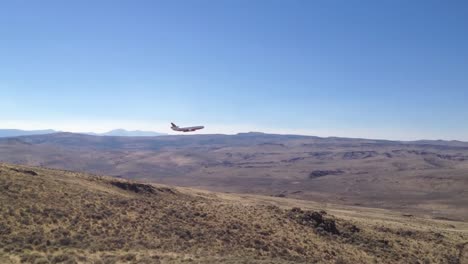 A-Fixed-Wing-Aircraft-Makes-Flame-Retardant-Drops-On-A-Wildfire-As-Firefighters-Set-Backfires