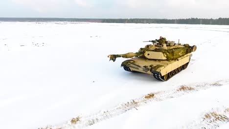 Good-Aerial-Of-A-Military-Tank-Maneuvering-Through-A-Snowy-Landscape-1