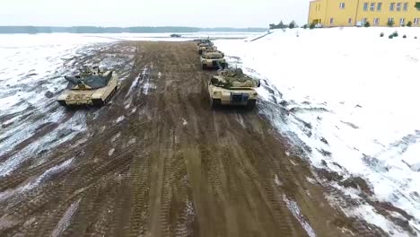 Aerial-Of-A-Military-Tank-Maneuvering-Through-A-Snowy-Landscape-3