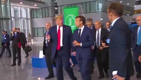 El-Presidente-Estadounidense,-Donald-Trump,-Se-Mueve-Entre-Una-Multitud-En-La-Cumbre-De-La-Otan-Conversando-Con-El-Presidente-Francés,-Emmanuel-Macron-2