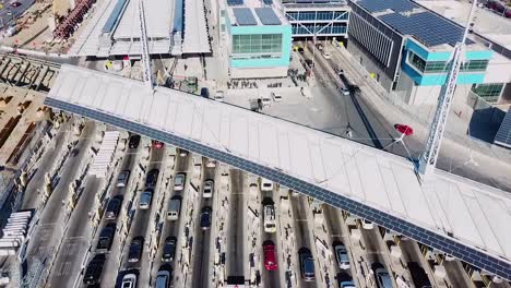 Panorámica-Aérea-Sobre-El-Cruce-Fronterizo-De-San-Ysidro-Tijuana-México-Con-Coches-Alineados-Por-Millas