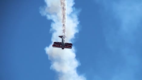 Ein-Doppeldecker-Macht-Einen-Zeitlupen-Roll-Stunt-Während-Der-Halbjährlichen-Flugschau-In-Hill-Afb-Utah-Mit-Rauch-Hinterher-With