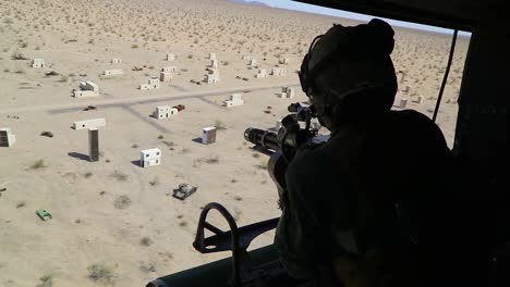 Ein-Soldat-Der-Armee-Feuert-In-Dieser-Trainingseinheit-Ein-Maschinengewehr-Aus-Einem-Huey-Hubschrauber-Auf-Ein-Arabisches-Modelldorf-Ab-Village