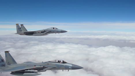American-F15-Fighter-Jets-Fly-In-Formation-High-Above-The-Clouds-And-Then-Peel-Off