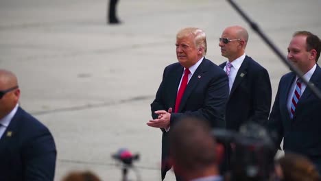 Der-Präsident-Der-Vereinigten-Staaten-Donald-J-Trump-Geht-Auf-Einem-Asphalt-Und-Grüßt-Bewundernde-Armeesoldaten-Bei-Einer-Rallye-Steigt-In-Limousine