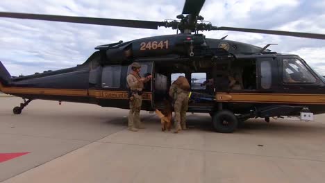 Miembros-De-La-Patrulla-Fronteriza-De-EE.-UU.-Caminan-Con-Un-Perro-Canino-K9-Hasta-Un-Helicóptero-Que-Espera