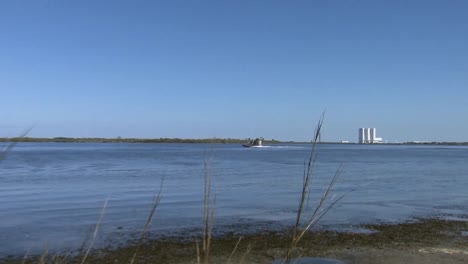 Polizeibeamte-Fahren-Mit-Airboats-Durch-Die-Sümpfe-Eines-National-Wildlife-Refuge-Floridas,-Vorbei-An-NASA-Gebäuden