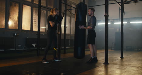 Frau-Schlägt-Boxsack-Im-Fitnessstudio