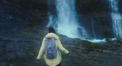Woman-Hiking-Up-to-Waterfall