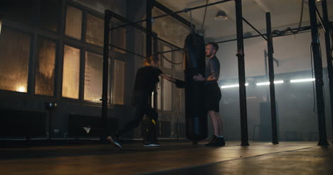 Woman-and-Trainer-Boxing-Punching-Bag