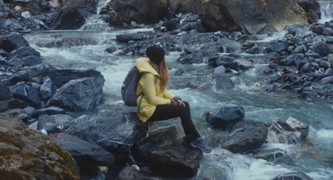 Wanderer-Sitzt-An-Einem-Fluss