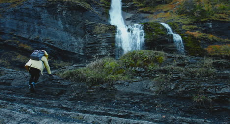 Girl-Hiking-Up-Towards-Waterfall