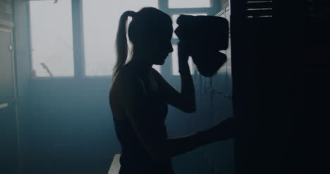 Woman-Putting-Boxing-Gloves-in-Locker-02